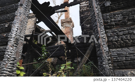 Burnt house remains after a fire, showing scorched wood and structural damage 137404220