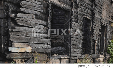 Burnt house structure showing extensive charring and fire damage 137404225