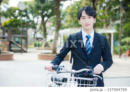 自転車を押して歩くビジネスマン 137404789