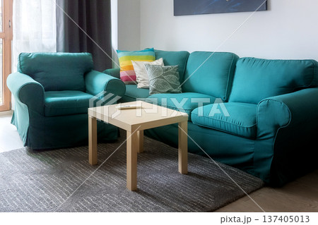 Cozy teal sofa with pillows and coffee table Cozy teal sofa with pillows and coffee table 137405013