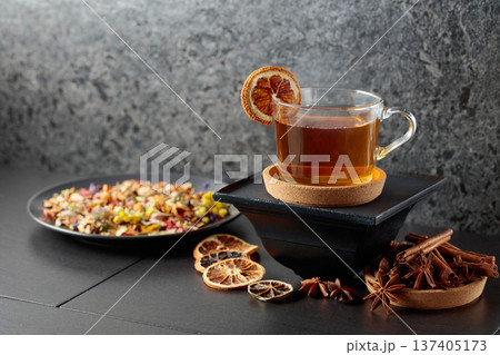 Cup of herbal tea with ingredients and slices of dried orange slices. 137405173