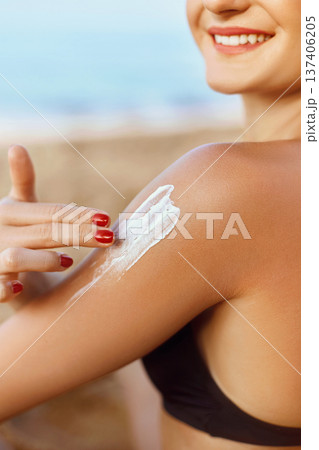 Sun Cream. Skin and Body Care. Woman in Bikini  Applying Sunscreen Solar on Tanned  Shoulder. Sun Protection lotion sunburn. Girl Holding Moisturizing Sunblock. 137406205