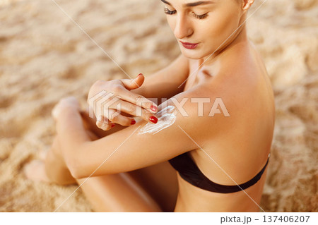 Woman smile applying sun cream on shoulder. Skincare. Body Sun protection. sunscreen. Female Usingr moisturizing lotion on skin.Skin Protection and dermatology 137406207