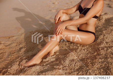 Beautiful Legs Outdoors By Beach Under Sunshine On Summer Day. Skincare. Protection Sun. Epilation Laser or Shaving Concept.Sunscreen on Feet 137406237
