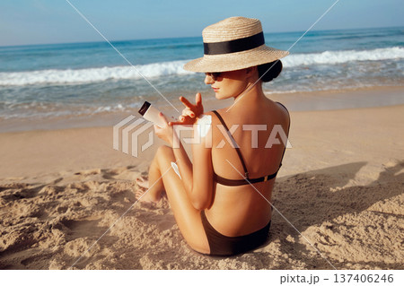 Sun Protection, girl using sunscreen to safe her skin healthy. Sexy young woman in bikini holding bottles of sunscreen in her hands. Skincare. Sun Protection, girl using sunscreen to safe her skin healthy. Sexy young woman in bikini holding bottles of sunscreen in her hands. Skincare. 137406246