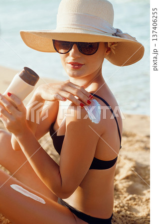 Beauty Woman smile applying sun cream on shoulder. Skincare. Body Sun protection. sunscreen. Female Using moisturizing lotion on skin.Skin Protection and dermatology Beauty Woman smile applying sun cream on shoulder. Skincare. Body Sun protection. sunscreen. Female Using moisturizing lotion on skin.Skin Protection and dermatology 137406255