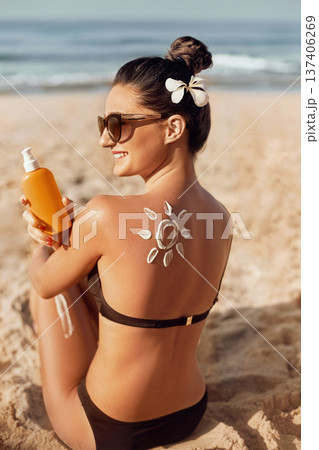 Skin care. Sun protection. Girl apply sun cream. Woman With Suntan Lotion At The Pool In Form Of The Heart. Portrait Of Female With the Drawn Sun On a Shoulder. Suncream Skin care. Sun protection. Girl apply sun cream. Woman With Suntan Lotion At The Pool In Form Of The Heart. Portrait Of Female With the Drawn Sun On a Shoulder. Suncream 137406269