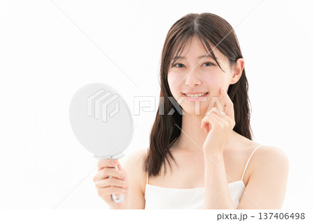 白背景でスキンケアをする女性のビューティーイメージ 137406498