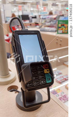 Payment terminal on checkout counter in retail store. 137406818