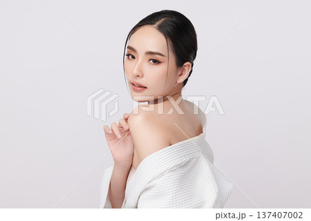 A beautiful young Asian woman with clean, fresh skin against a white background. Skincare, facial treatment, cosmetology, beauty, and spa. An elegant portrait of an Asian woman. 137407002