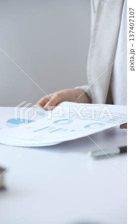 Professional businesswoman reviewing financial documents and charts, performing data analysis for business planning and decision making in a professional office background. Business people Professional businesswoman reviewing financial documents and charts, performing data analysis for business planning and decision making in a professional office background. Business people 137407107