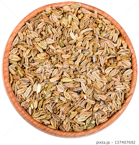 Fennel seeds in a small wooden bow isolated on white. Fennel seeds in a small wooden bow isolated on white. 137407692