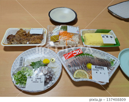 日本の家庭的な夕食シーンを彩るパック入りの新鮮なお刺身と手軽な惣菜セット 137408809