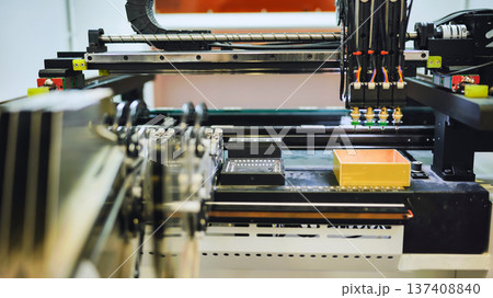 Robotic arm performing pick and place operation in electronics manufacturing Robotic arm performing pick and place operation in electronics manufacturing 137408840
