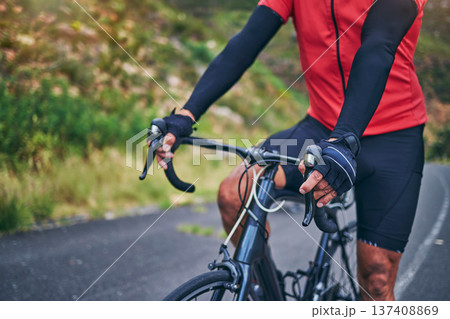 Fitness, cycling and hands with person on bike in nature for sports, training or challenge. Exercise, workout and health with closeup of man on bicycle in mountains for energy, freedom or performance 137408869