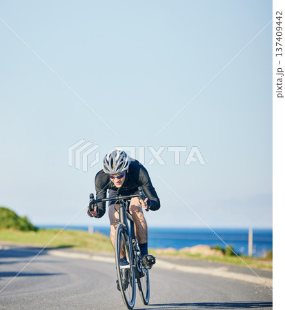 Speed, fitness and cyclist on bicycle on road in mountain with blue sky, exercise adventure trail and speed. Cycling race, nature and man with bike for fast workout, training motivation or energy. 137409442