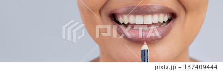Makeup, beauty and lips of woman with pencil in studio for wellness, skincare product and cosmetics. Salon, banner and face zoom of person with lipstick or lip liner for glamour, makeover and glow 137409444