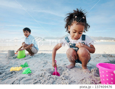 Boy, girl and shovel with bucket, beach and digging sand with playing, outdoor and vacation in summer. Kids, siblings and plastic toys for sandcastle, construction game and happy for holiday by ocean 137409476