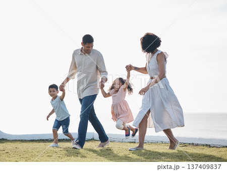 Happy family, holding hands and outdoor at a park with a love, care and happiness together in nature. Young man and woman or parents with children for walk, travel and playing on holiday or vacation 137409837