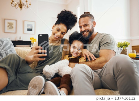 Interracial parents, child and selfie on sofa, smile and hug for love, bonding and memory on web blog. Mom, dad and kid for photography, profile picture and happy for social media app in family house 137410112