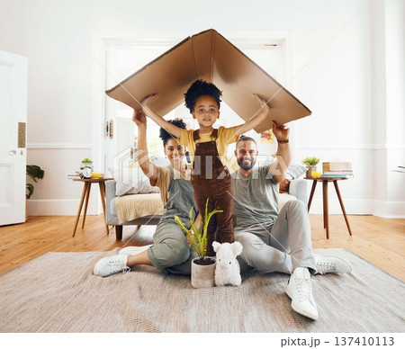 Portrait, family and a boy with cardboard for insurance in the living room of their home together. Mother, father and daughter in a house for security or safety in real estate and property finance Portrait, family and a boy with cardboard for insurance in the living room of their home together. Mother, father and daughter in a house for security or safety in real estate and property finance 137410113