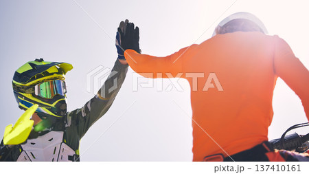 Motorcycle men, high five and outdoor for race, success or achievement with speed, goals and teamwork. Motorbike athlete, champion partnership and congratulations with helmet, safety and support Motorcycle men, high five and outdoor for race, success or achievement with speed, goals and teamwork. Motorbike athlete, champion partnership and congratulations with helmet, safety and support 137410161