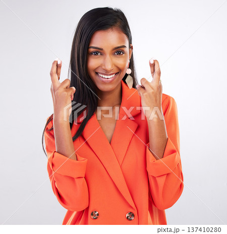 Portrait, smile and woman with fingers crossed in studio for good luck, hope or wish on grey background. Happy, face and female model with optimistic hand emoji for review, feedback or vote results 137410280