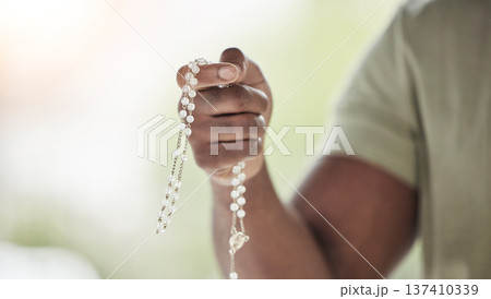 Rosary, man hands and prayer beads in a home with hop, christian praise and religion. Praying, necklace and worship in a house with hope, gratitude and spiritual guide for faith support and healing 137410339