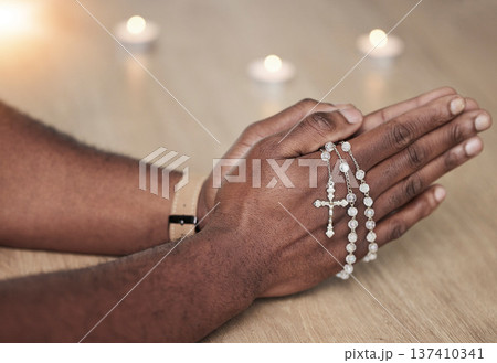 Rosary, man hand and cross prayer beads in a home with hope, christian praise and religion. Praying, necklace and worship in a house with god, gratitude and spiritual guide for support and healing 137410341