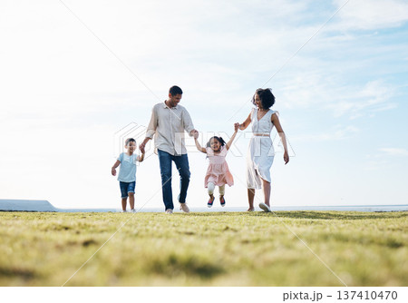 Holding hands, family and outdoor at a park with love, care and happiness together in nature. Young man and woman or parents with children on walk, sky and playing on fun journey or travel holiday 137410470