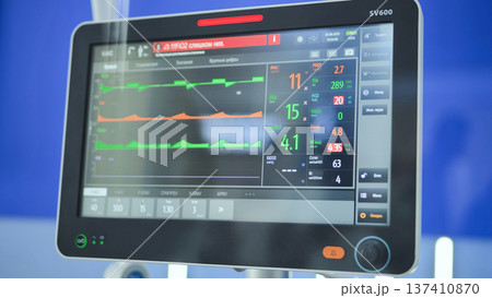 Ventilator screen showing medical data, graphs, and numbers in an intensive care unit 137410870