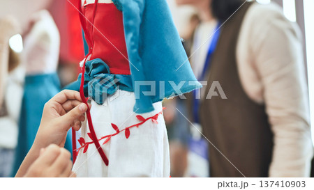 Hands adjusting details on a colorful fashion design dress on a mannequin Hands adjusting details on a colorful fashion design dress on a mannequin 137410903