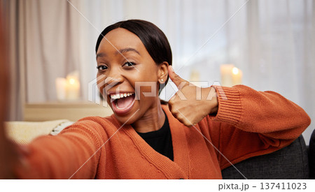 Selfie, black woman and thumbs up at home with a smile for success, motivation and excited. Portrait, happy and African female person in a living room with a like, yes and emoji hand sign at house 137411023