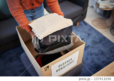 Donation box, charity and hands with clothes for nonprofit and cardboard container at home. Moving, donating and house with giveaway and spring cleaning for community care support with packing Donation box, charity and hands with clothes for nonprofit and cardboard container at home. Moving, donating and house with giveaway and spring cleaning for community care support with packing 137411036