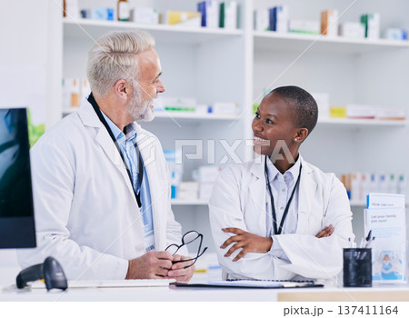 Discussion, team and pharmacists with medication in pharmacy for healthcare or medical career. Conversation, medicine and senior chemist mentor talking to female pharmaceutical student by dispensary. Discussion, team and pharmacists with medication in pharmacy for healthcare or medical career. Conversation, medicine and senior chemist mentor talking to female pharmaceutical student by dispensary. 137411164