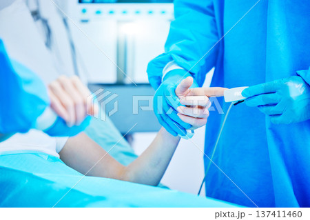 Surgery, doctor and finger with heart rate monitor for medical care, operation and procedure. Healthcare, hospital and hands of surgeons with cardiology equipment for patient wellness in theater 137411460