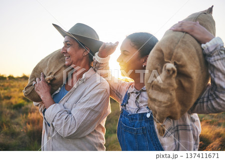 Farm harvest, women and countryside with a smile from working on a grass field with grain bag. Sustainability, eco friendly and agriculture outdoor at sunset in nature with farmer management mission Farm harvest, women and countryside with a smile from working on a grass field with grain bag. Sustainability, eco friendly and agriculture outdoor at sunset in nature with farmer management mission 137411671