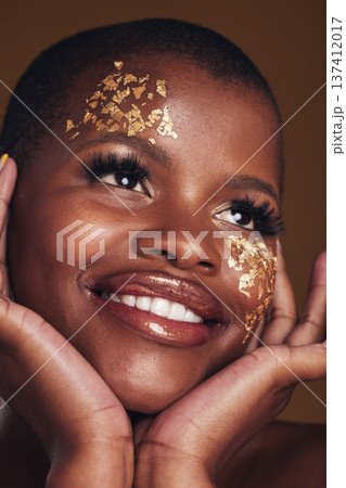Gold, makeup and woman face closeup with a smile from luxury treatment and facial spa mask. Glitter, golden dermatology and African female person happy from skincare and golden cosmetics in studio 137412017