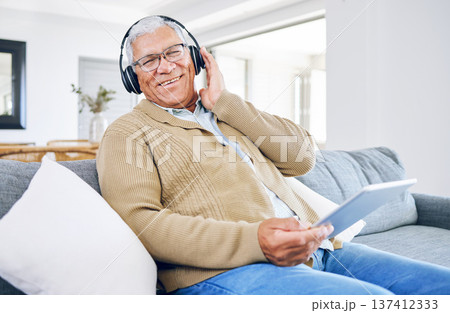 Portrait, home and old man with tablet, headphones and smile with connection, streaming music and radio. Senior person, technology and pensioner with headset, listening to audio and sound on a couch 137412333