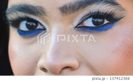 Bangladeshi girl wearing vibrant blue eye makeup looking up Bangladeshi girl wearing vibrant blue eye makeup looking up 137412368