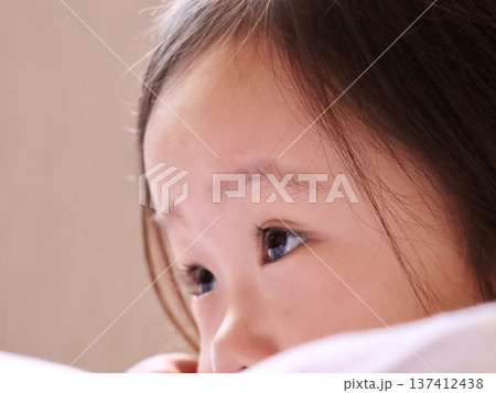 真剣な表情で何かを見つめる3歳の女の子の横顔アップ 日本の子供ポートレート｜育児・教育・子育て素材 137412438