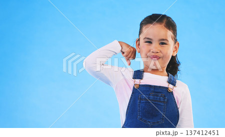 Portrait, girl child and champion, winner and emoji with happiness, strong and excited isolated on blue background. Power, mockup space and winning with success, body language and happy kid in studio 137412451