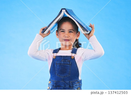 School, head and portrait of child with book for knowledge or learning isolated in a studio blue background. Clever, smart and young girl kid with notebook happy for education, story or reading School, head and portrait of child with book for knowledge or learning isolated in a studio blue background. Clever, smart and young girl kid with notebook happy for education, story or reading 137412503