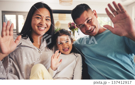 Parents, girl and wave in video call, portrait and smile for hello, contact and relax in family home. Asian father, mother and daughter with hand, sign language and greeting for respect in Jakarta Parents, girl and wave in video call, portrait and smile for hello, contact and relax in family home. Asian father, mother and daughter with hand, sign language and greeting for respect in Jakarta 137412917