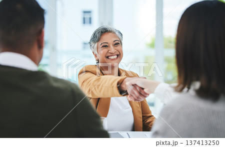 Handshake, job interview or business people with a happy mature woman for partnership in office. We are hiring, smile or business people shaking hands for success, promotion or negotiation in meeting Handshake, job interview or business people with a happy mature woman for partnership in office. We are hiring, smile or business people shaking hands for success, promotion or negotiation in meeting 137413250