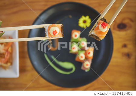 Sushi, seafood and chopsticks in a chinese restaurant from above for dining or traditional cuisine. Salmon, menu and raw food with am asian dish on a table in a local eatery for hunger or nutrition 137413409