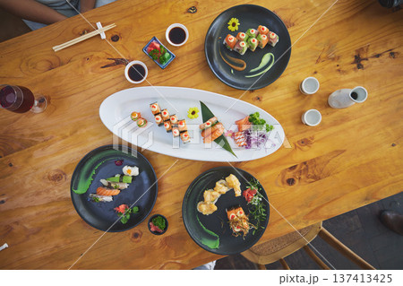 Sushi, seafood and chopsticks in an asian restaurant from above for fine dining or traditional cuisine. Salmon, menu and chinese food with a dish on a table in a local eatery for hunger or nutrition 137413425