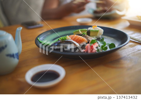 Sushi, food and chopsticks in a chinese restaurant closeup for fine dining or traditional cuisine. Salmon, menu and seafood with an asian dish on a table in a local eatery for hunger or nutrition Sushi, food and chopsticks in a chinese restaurant closeup for fine dining or traditional cuisine. Salmon, menu and seafood with an asian dish on a table in a local eatery for hunger or nutrition 137413432