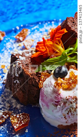 Gourmet chocolate cake served with berry-swirl ice cream and edible flowers Gourmet chocolate cake served with berry-swirl ice cream and edible flowers 137413465