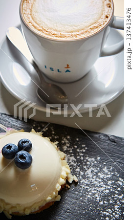 Elegant white chocolate mousse dome dessert topped with fresh blueberries and a floral petal Elegant white chocolate mousse dome dessert topped with fresh blueberries and a floral petal 137413476